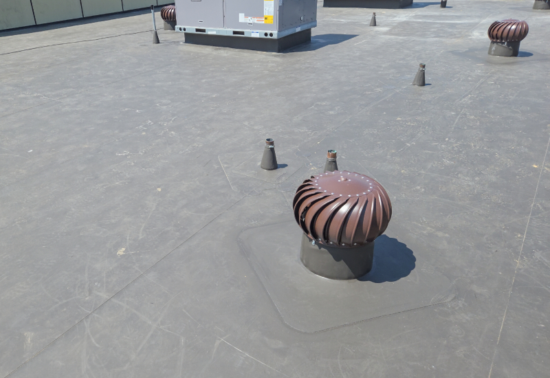 Close-up showing TPO roofing around rooftop ventilation and roof penetrations