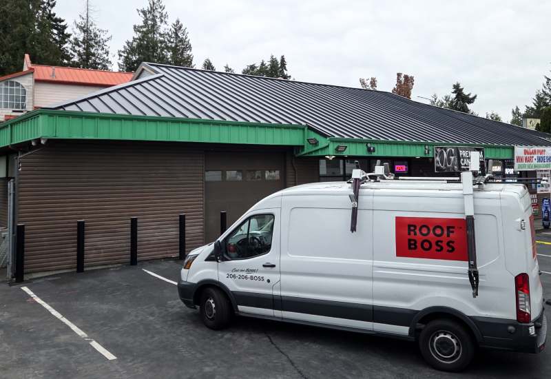 Completed metal roof in Matte Black with ROOF BOSS vehicle in foreground viewed from the ground