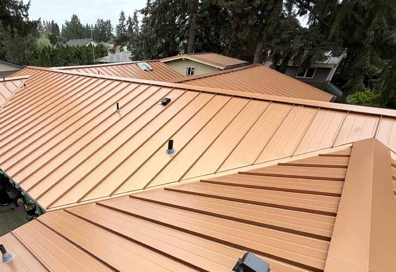 Close-up showing the standing seam metal roof panels in Copper Penny with matching trim and flashing around intersecting rooflines
