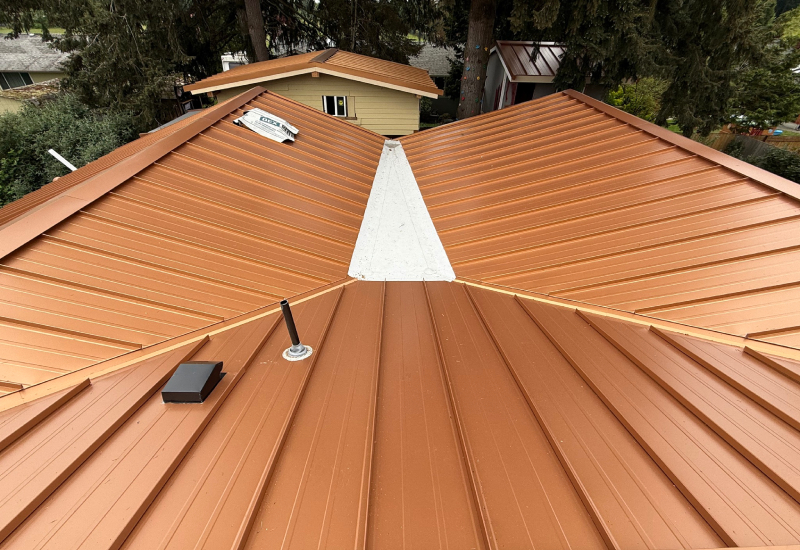 Close-up of standing seam metal roofing surrounding a flat roof section with membrane roofing