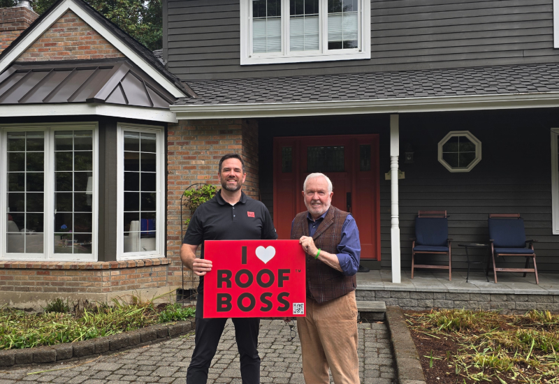 ROOF BOSS customers with estimator holding an 'I Love ROOF BOSS' sign after completion of the roofing project