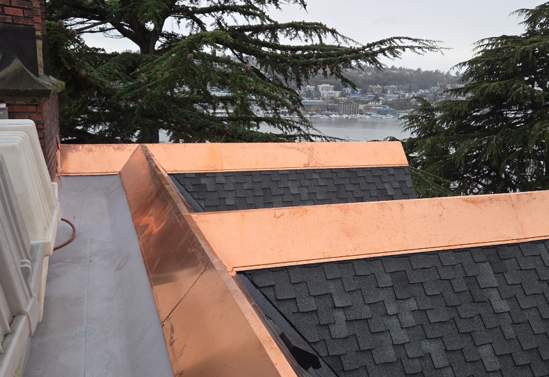 Close-up of custom copper ridge caps and metal coping installed along the home's rooflines