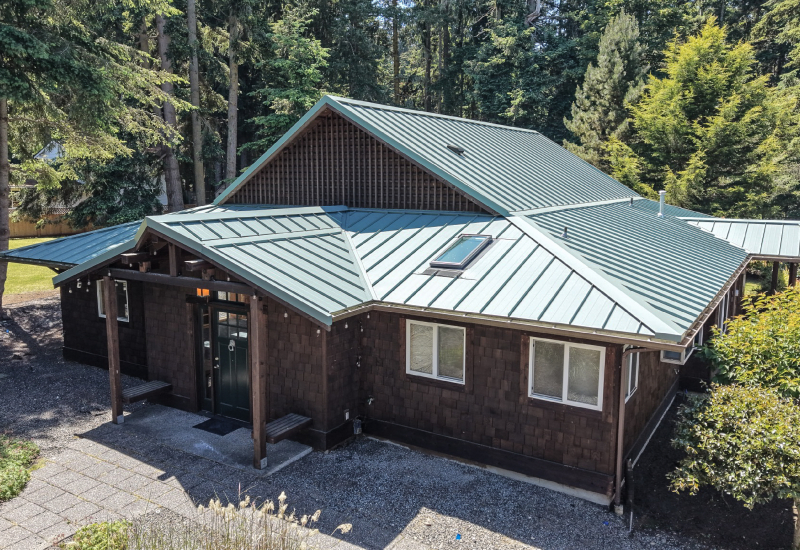Aerial view of the completed Imperial Metals 24 GA ribbed standing seam metal roof in Hemlock Green on a home in Langley, WA.