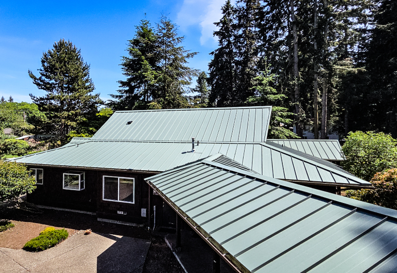 Completed metal roofing extending across the home's connected rooflines and breezeway.