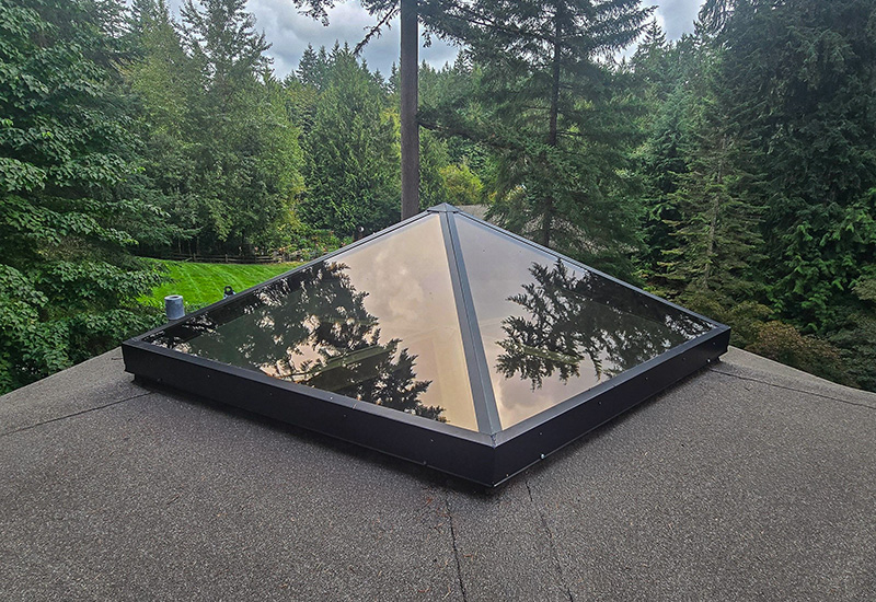 Completed custom TAM pyramid skylight with dark glazing and black metal framing